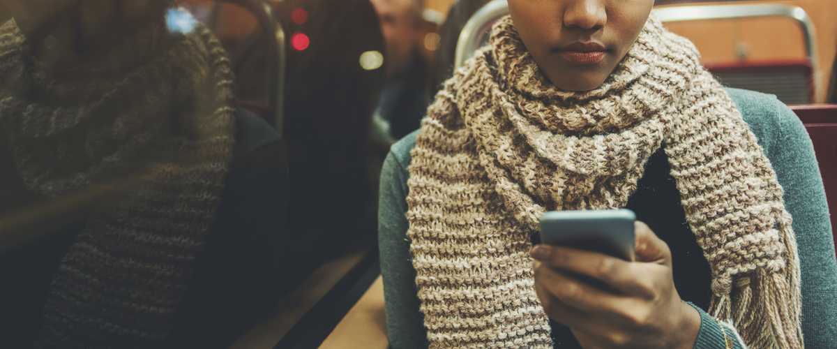 Young woman on a bus looking at phone